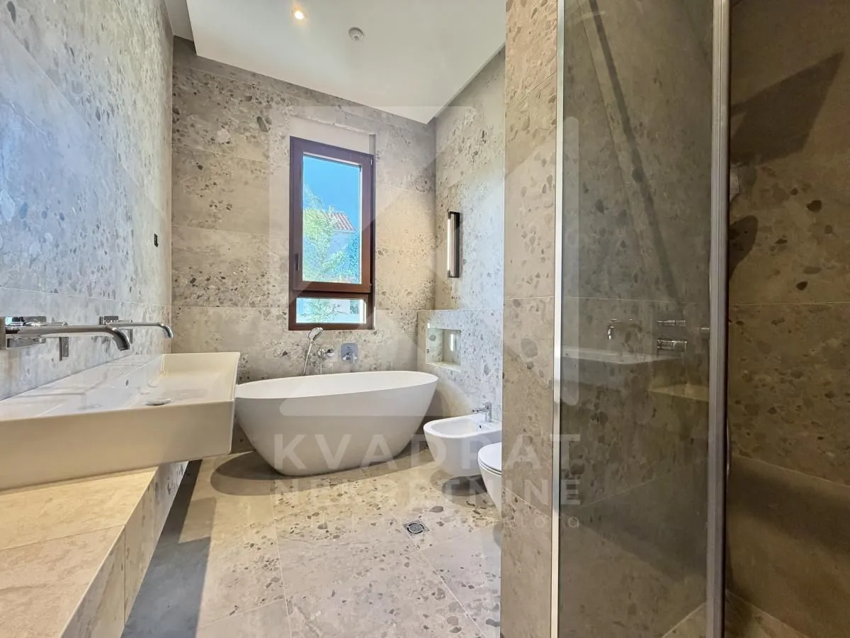 Modern bathroom with a bathtub, walk-in shower, and washbasin.