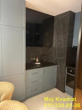 Moderna kuhinja sa plavim elementima i tamnom radnom površinom. - image 3