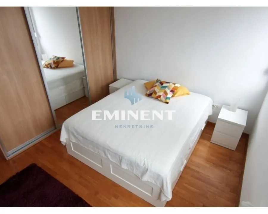 Furnished bedroom with a double bed and a fitted wardrobe.