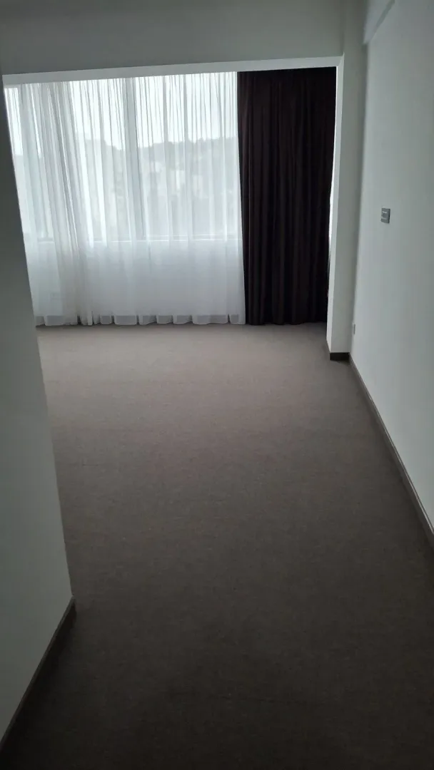 An empty room with carpet and a large window.