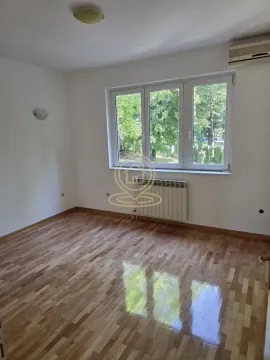 Empty room with hardwood flooring and a view of greenery through the window. - image 8