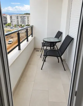 Natkriveni balkon sa garniturom za sjedenje i pogledom na okolinu. - image 8