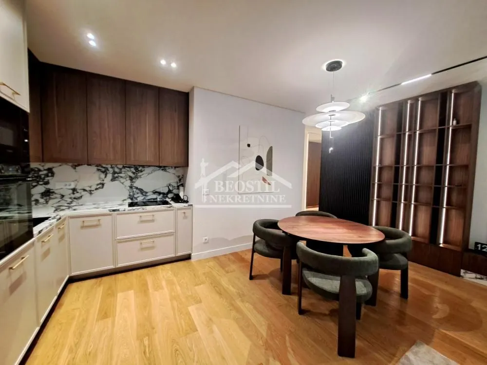 Modern kitchen with a dining area and wooden flooring.