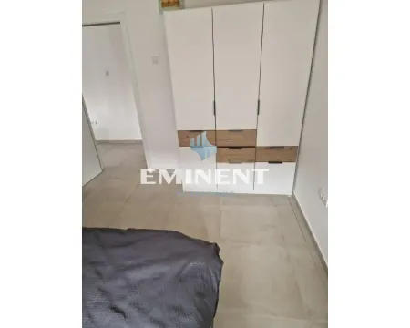 Spavaća soba sa velikim belim ormanom i krevetom. - image 6