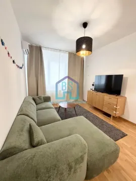 Dnevni boravak sa ugaonom garniturom, televizorom i drvenom komodom. - image 2