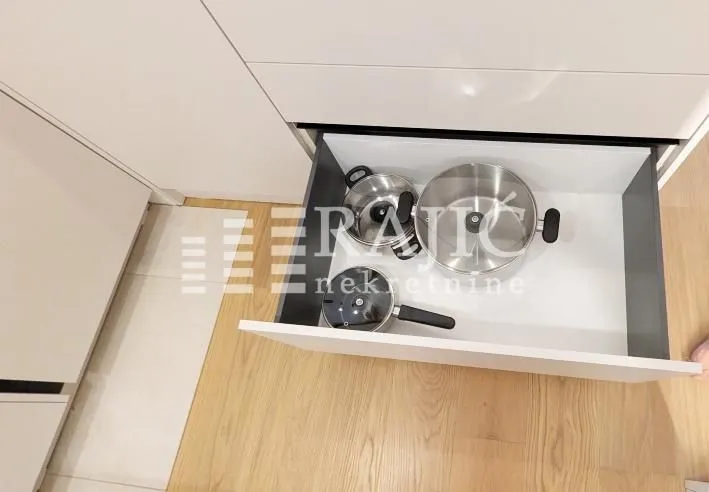 Open kitchen drawer containing pots.