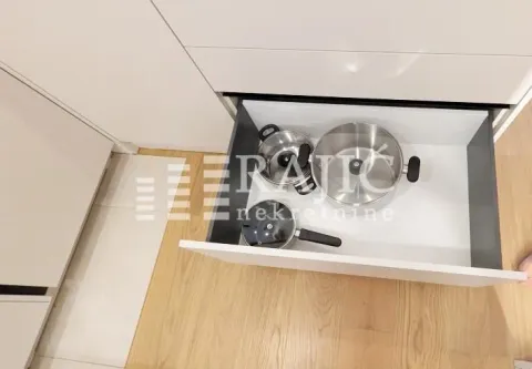 Open kitchen drawer containing pots. - image 7