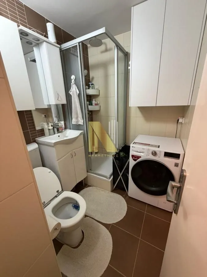 Kompaktno opremljeno kupatilo sa tuš kabinom, umivaonikom, WC šoljom i veš mašinom.