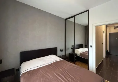 Furnished bedroom with a double bed, mirrored wardrobe, and a view of the hallway. - image 7