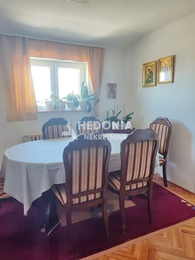 Trpezarija sa stolom, stolicama i prozorom.