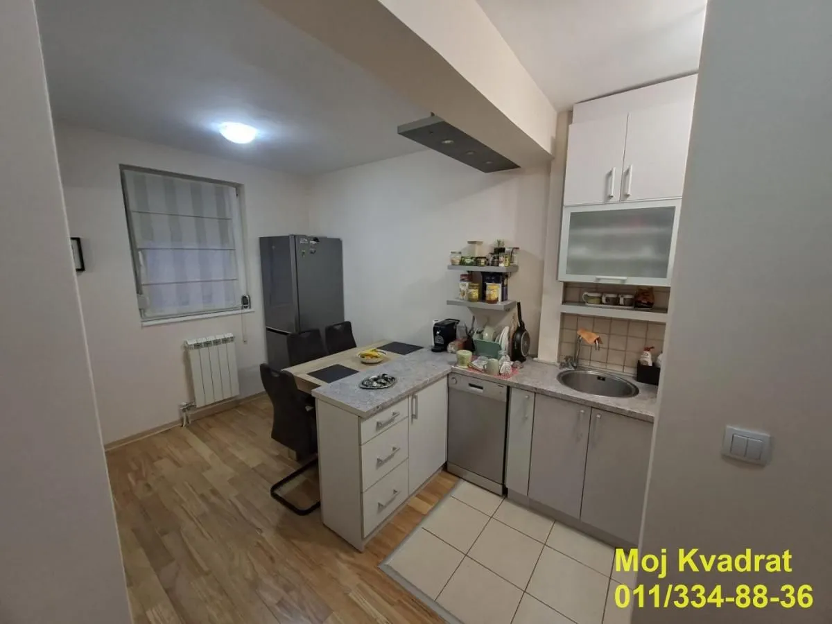 Manja kuhinja sa elementima i trpezarijskim stolom.