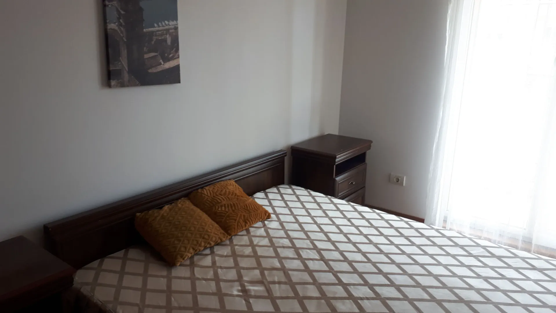 Furnished bedroom with a double bed and a nightstand.