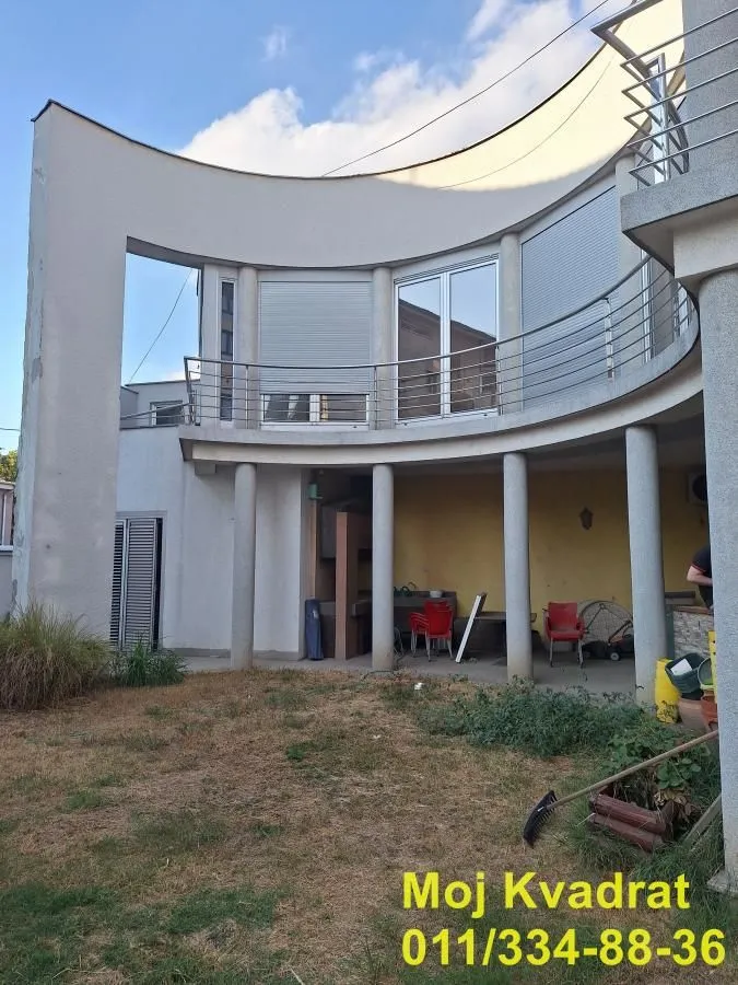 Pogled na spoljašnjost kuće sa terasom i dvorištem.
