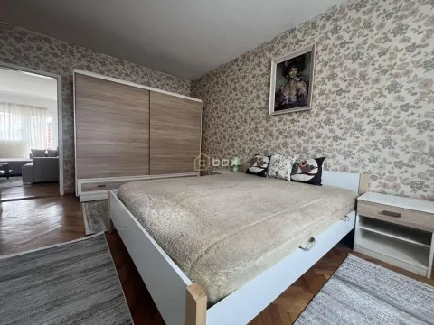 Furnished bedroom with a double bed, wardrobe, and patterned wallpaper. - image 9