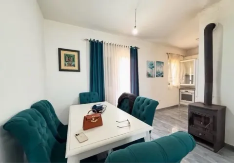 Living room with dining area and wood-burning stove. - image 13