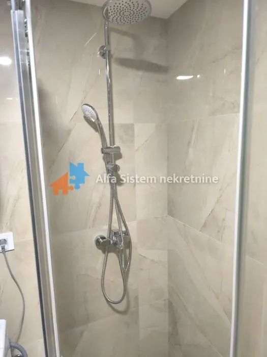 Shower cabin with a shower set and tiles in the bathroom.