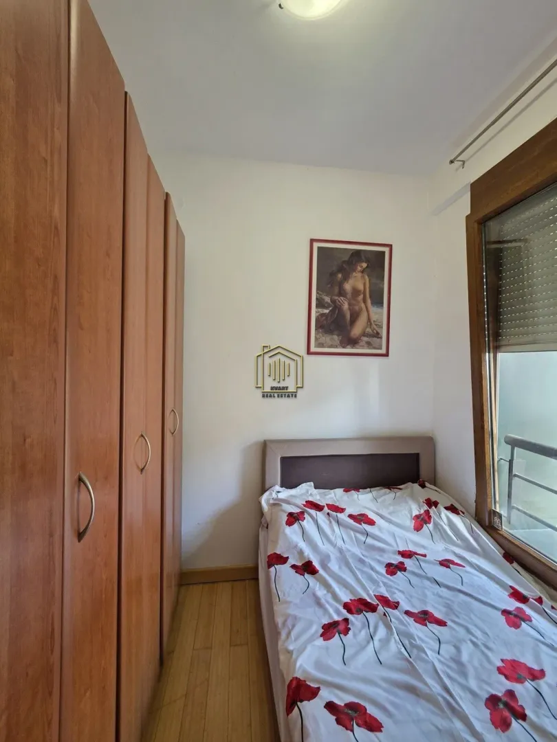 Small bedroom with a bed, built-in wardrobe, and window.