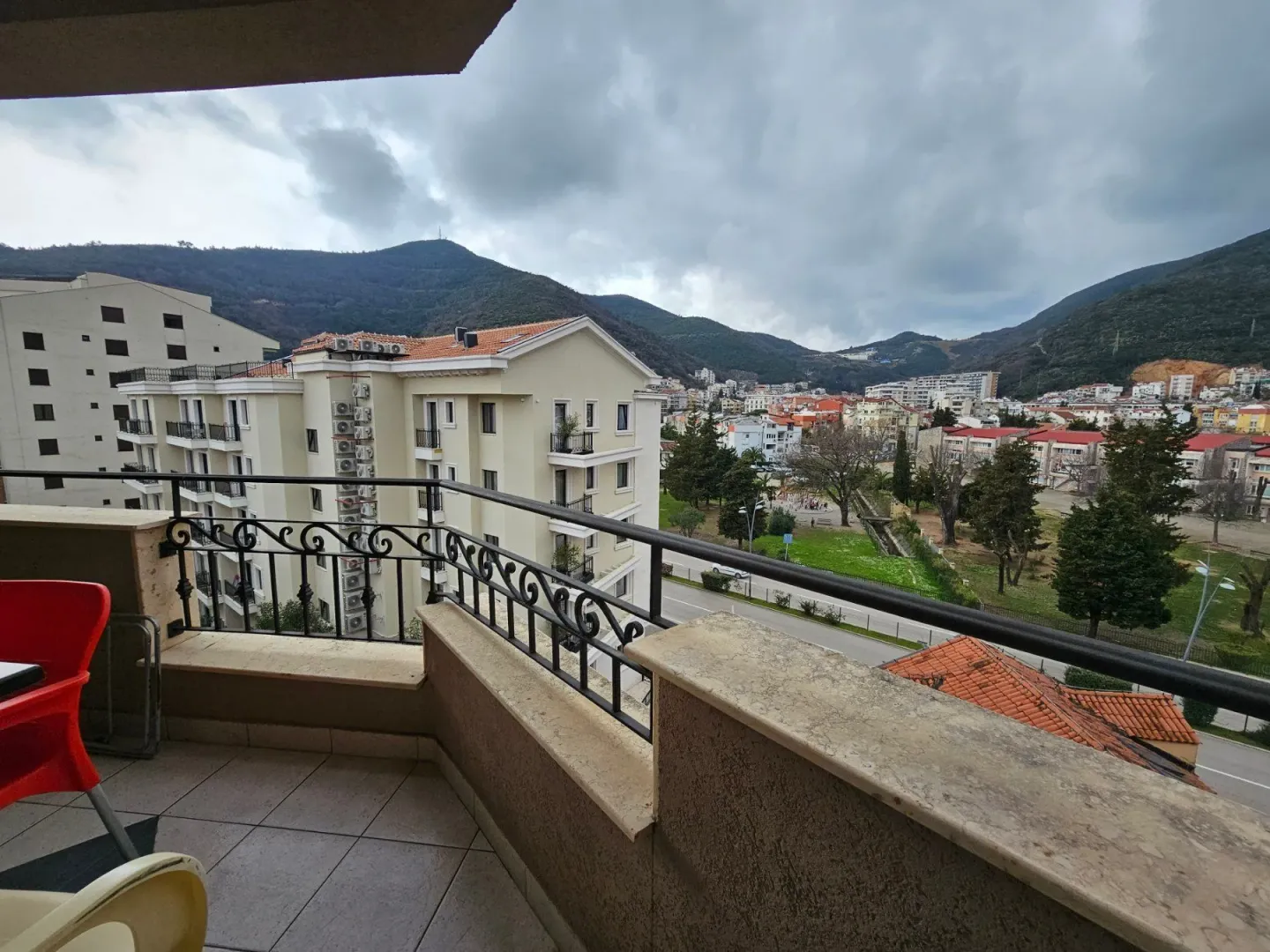 View from the balcony towards surrounding buildings, the town, and hills in the background.