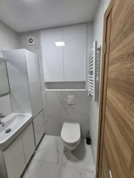 Moderno opremljeno kupatilo sa bijelim namještajem i mermernim pločicama. - image 6