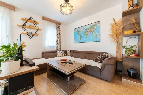 Living room with a sectional sofa, coffee table, and a world map on the wall. - image 13