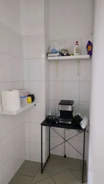 Small kitchen corner with a coffee machine and shelves. - image 8