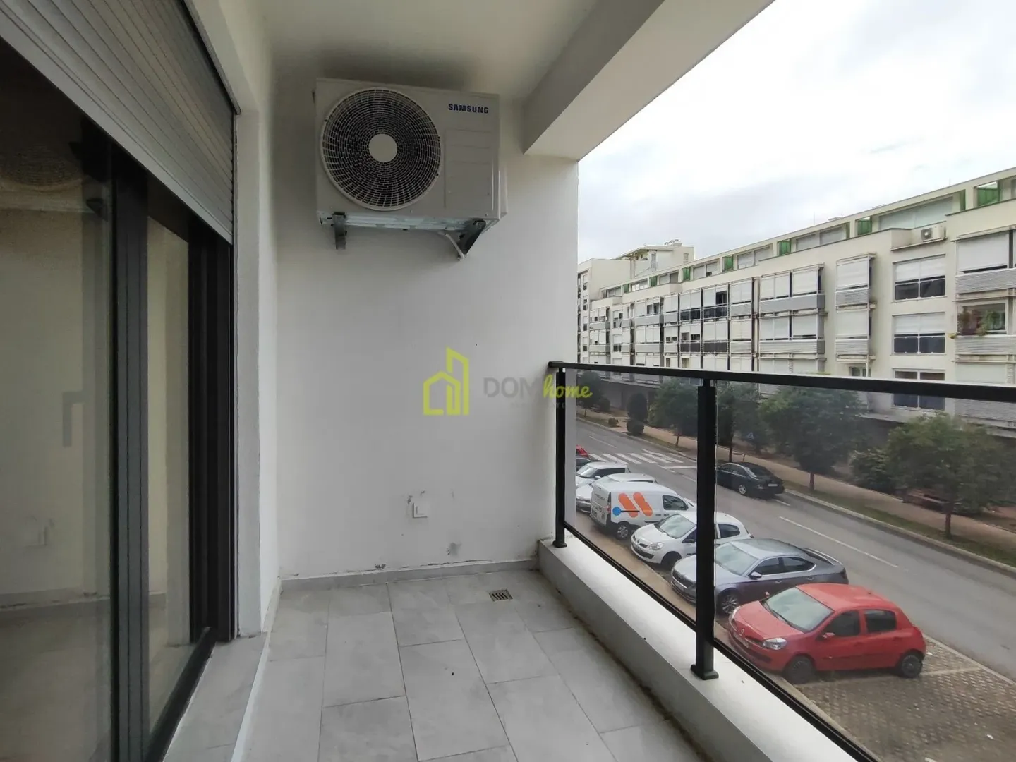 Covered balcony overlooking the street with an outdoor air conditioning unit.