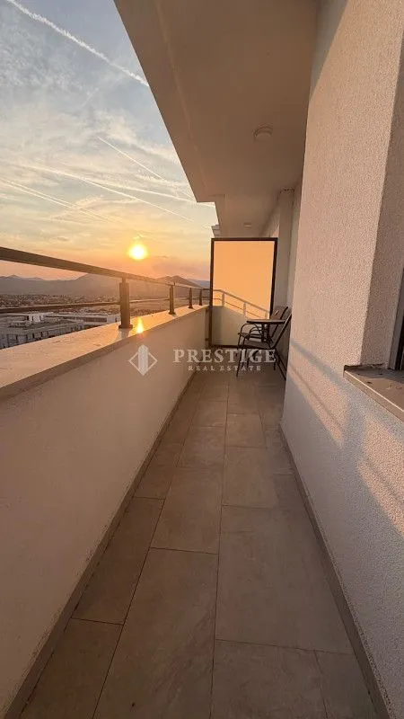 Spacious terrace with seating furniture and a sunset view.