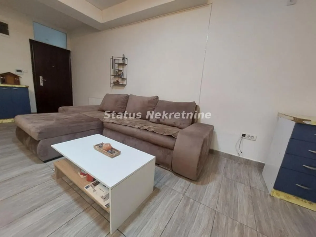 Dnevna soba sa ugaonom garniturom i belim stočićem.