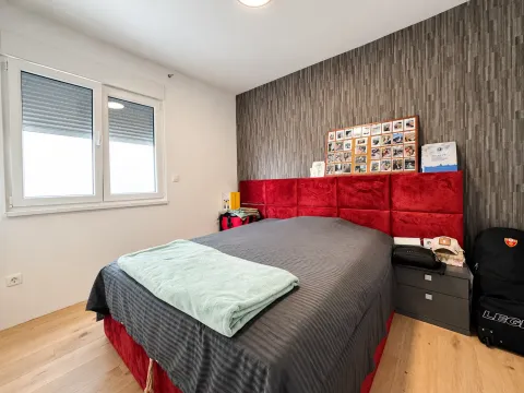 Spavaća soba sa bračnim krevetom, crvenim uzglavljem i prozorom. - image 12
