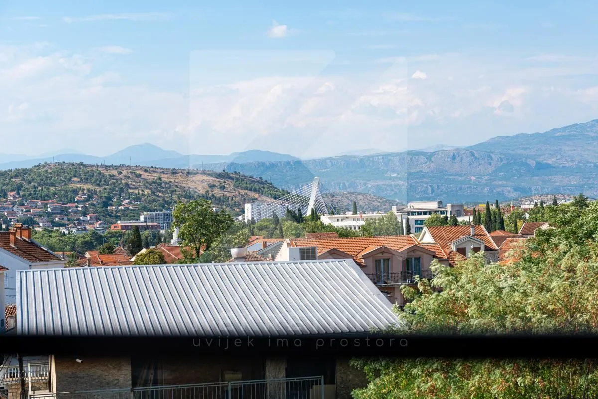 View of the city with hills and mountains in the background.