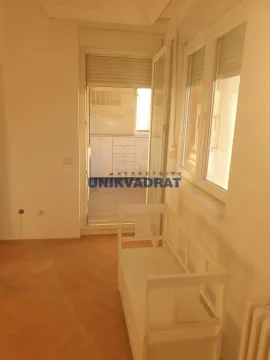Pogled iz sobe na zatvorenu terasu sa ugradnim elementima i belom klupom. - image 3