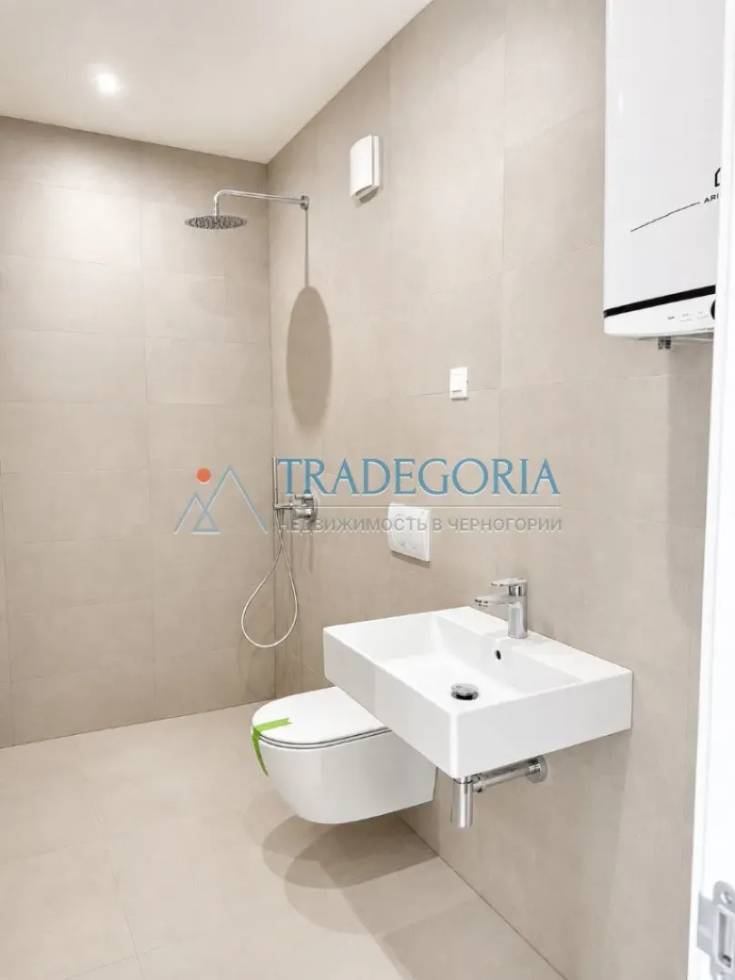 Moderne kupatilo sa tuš kabinom, umivaonikom i WC šoljom.