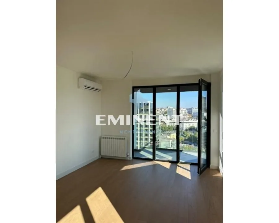 Empty room with wooden flooring and access to the terrace.
