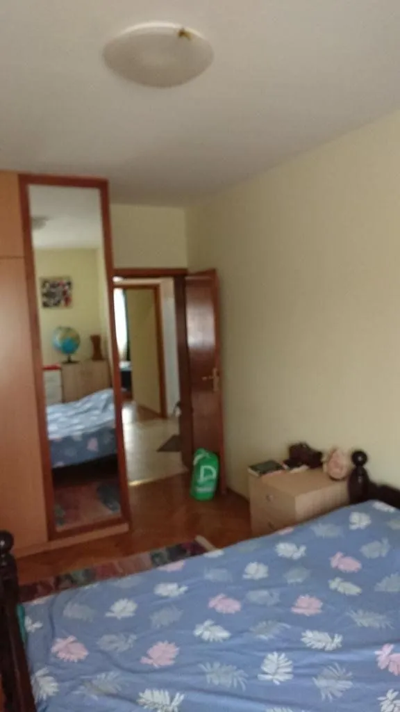 Furnished bedroom with a double bed, wardrobe, and a view of the hallway.