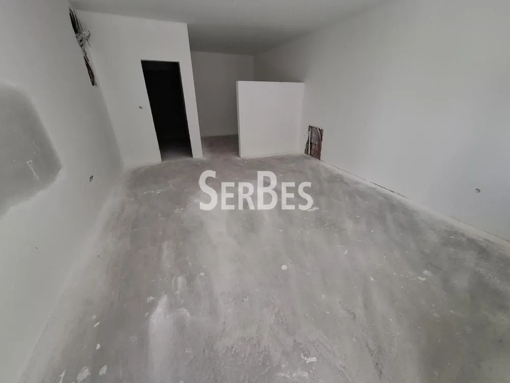 Prazna prostorija u sivoj fazi sa okrečenim zidovima.