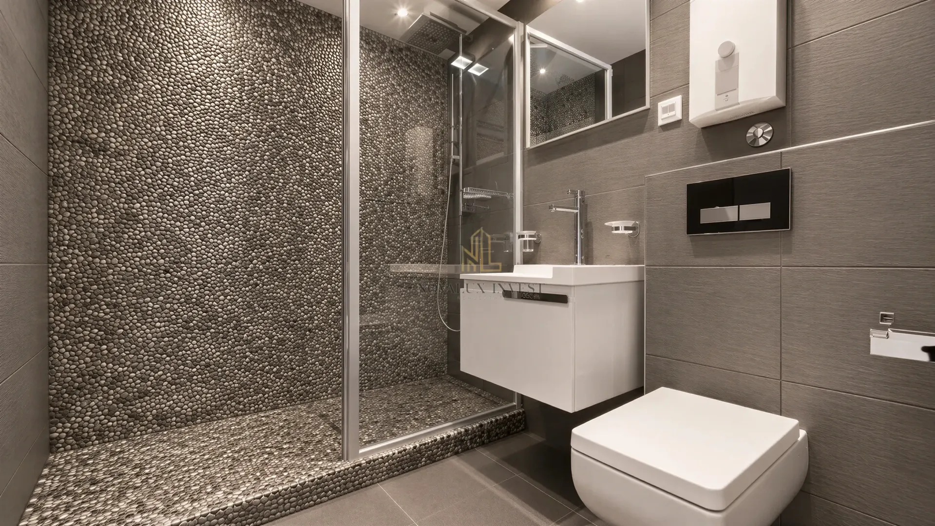 Modernly equipped bathroom with a pebble-tiled shower cabin.