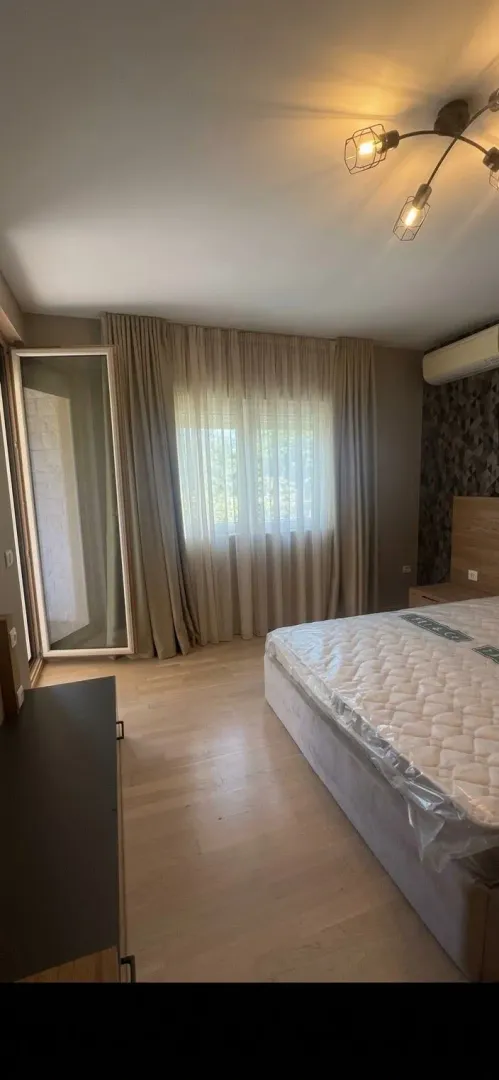 Namještena spavaća soba sa bračnim krevetom i izlazom na terasu.