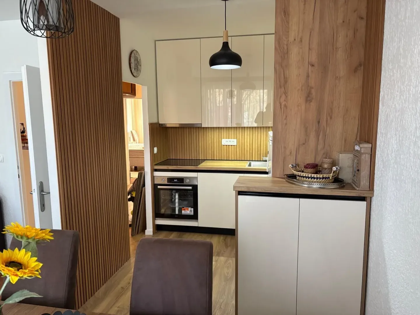 Modern kitchen with light cabinets and wooden details.