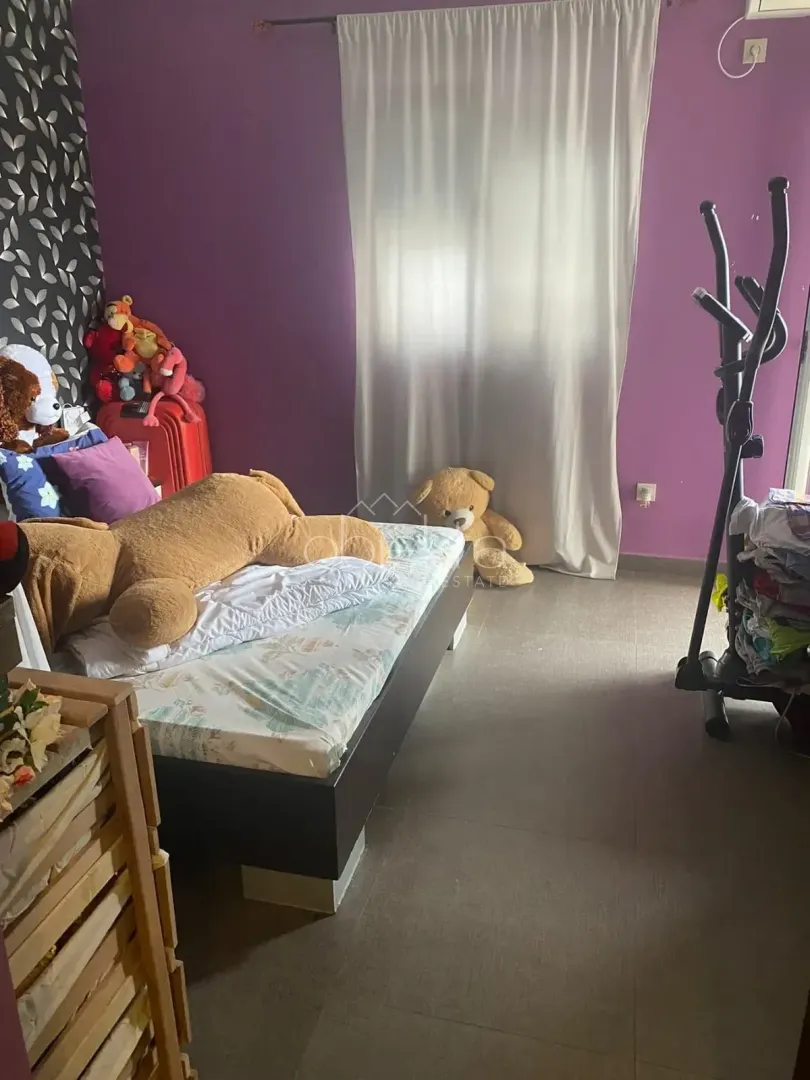 Bedroom with a bed, purple walls and toys.