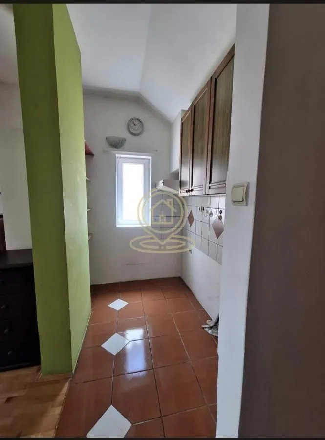Manja kuhinja sa podnim pločicama i drvenim elementima.