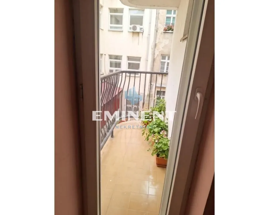 Pogled na manji balkon sa ogradom i saksijama sa cvećem.