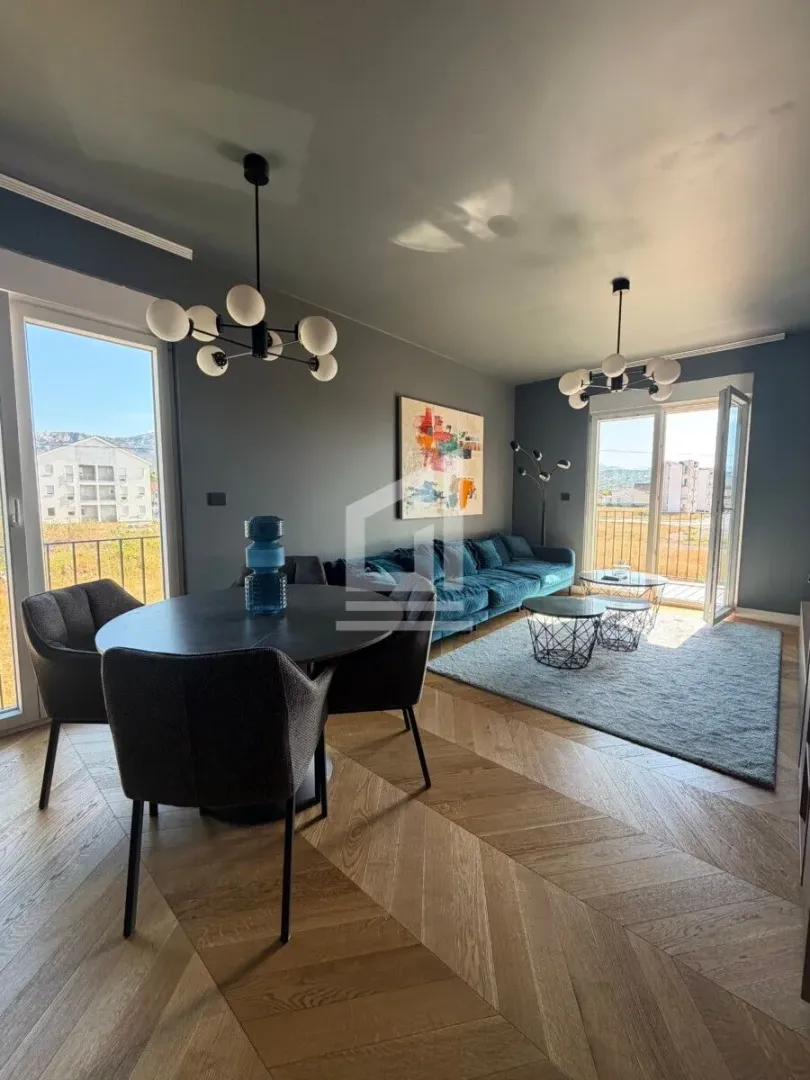 Spacious living room with a dining area, sofa set, and access to the terrace.