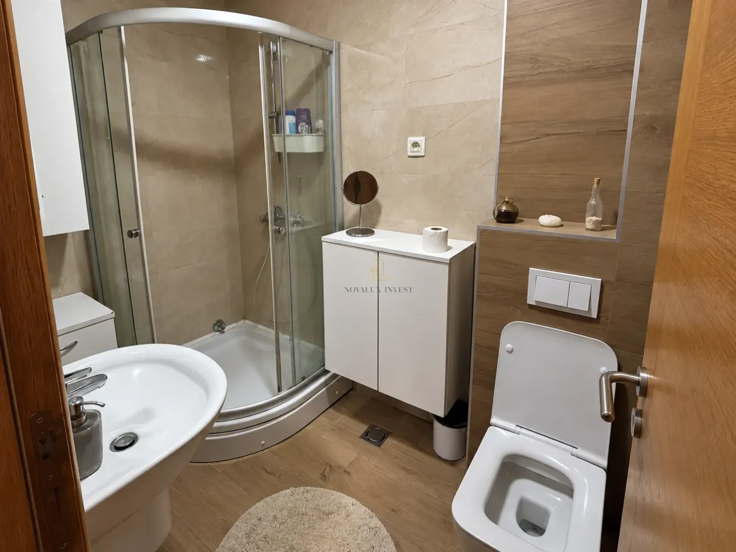 Modern bathroom with a shower cabin, washbasin, and toilet.
