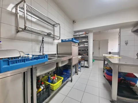 Commercial kitchen with stainless steel sink and shelving units. - image 8