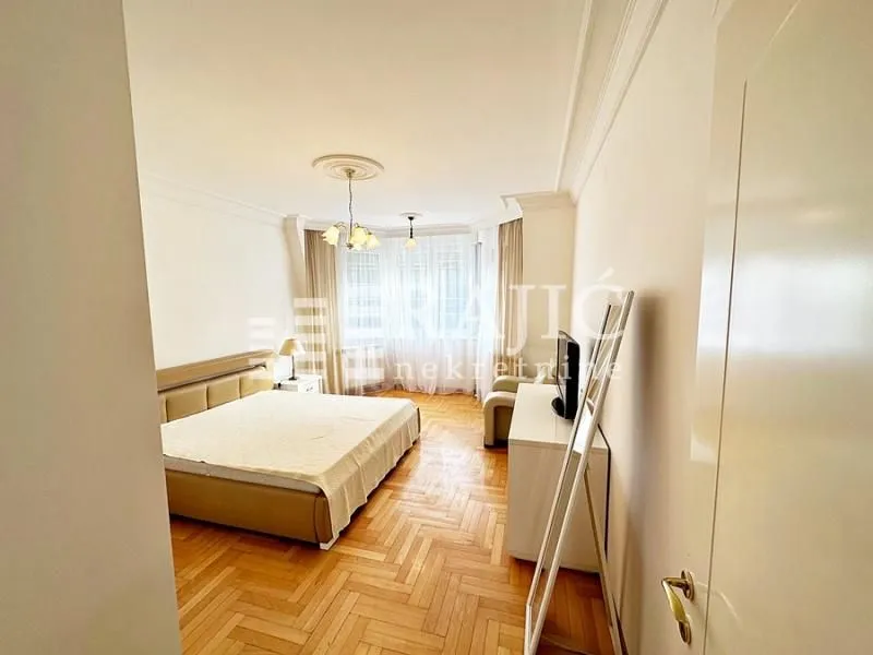 Spacious bedroom with a double bed and parquet flooring.
