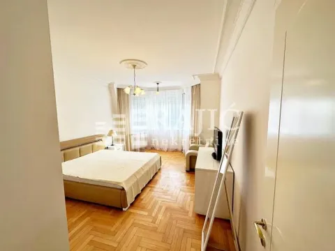 Spacious bedroom with a double bed and parquet flooring. - image 4