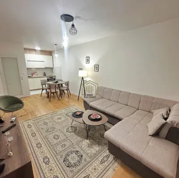 Living room with a sofa and a dining area in the background. - image 9