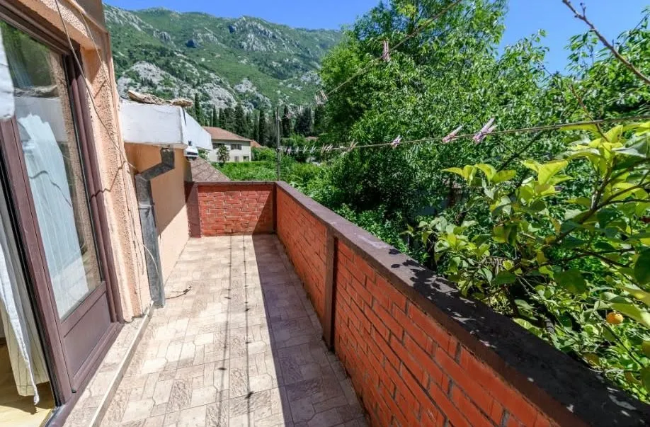 Spacious balcony with a view of the mountains and greenery.