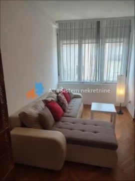 Dnevna soba sa ugaonom garniturom i prozorom sa zavesama. - image 2