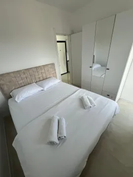 Bright bedroom with a double bed and a white wardrobe. - image 7